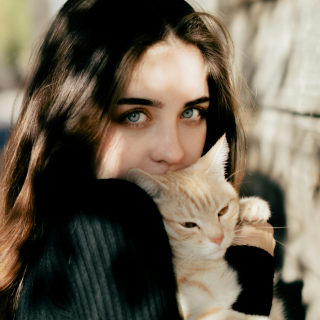 HOME 19 Jovem de olhos claros abraçando gato laranja de pelagem curta que olha para o lado com expressão tranquila